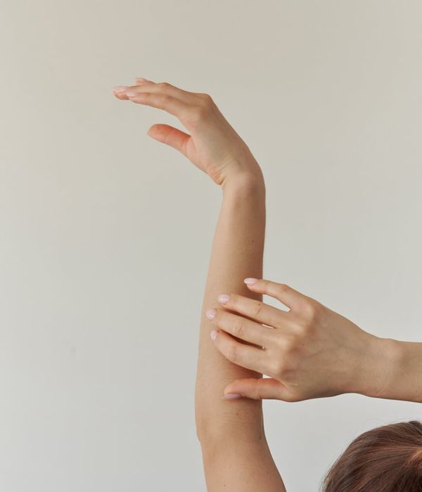 Woman in a calm yoga pose with a ruby light accent.